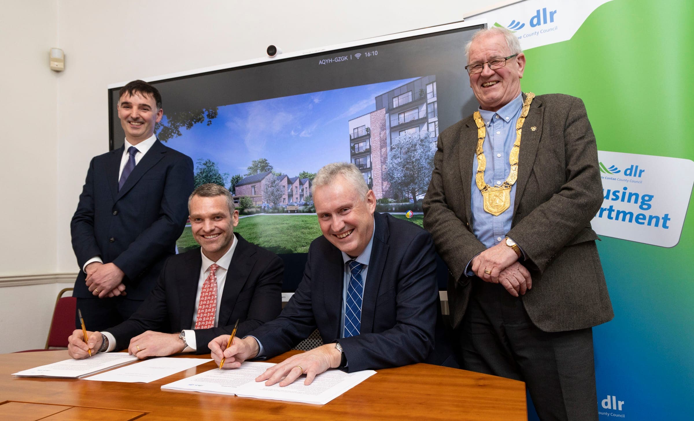 Contracts being signed for Emmet Gardens, Dundrum: Conor Rhatigan, Managing Director of Winterbrook, and Frank Curran, Chief Executive of Dún Laoghaire–Rathdown County Council, at the table, with Gerard O'Sullivan, Director of Housing, and Cathaoirleach Jim Gildea standing